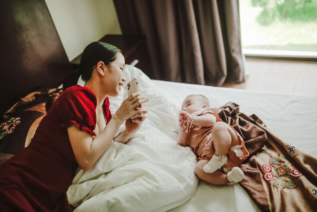 Mother and baby resting on bed in morning in bedroom