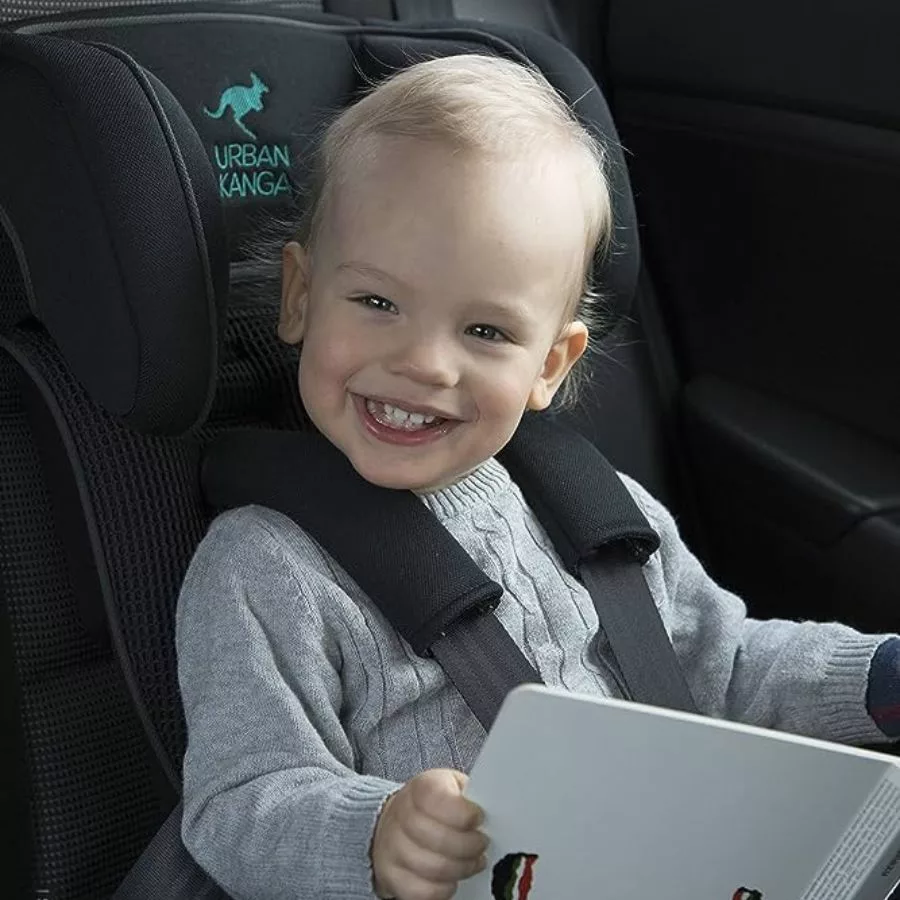 little blonde boy sitting in an urban kanga car seat