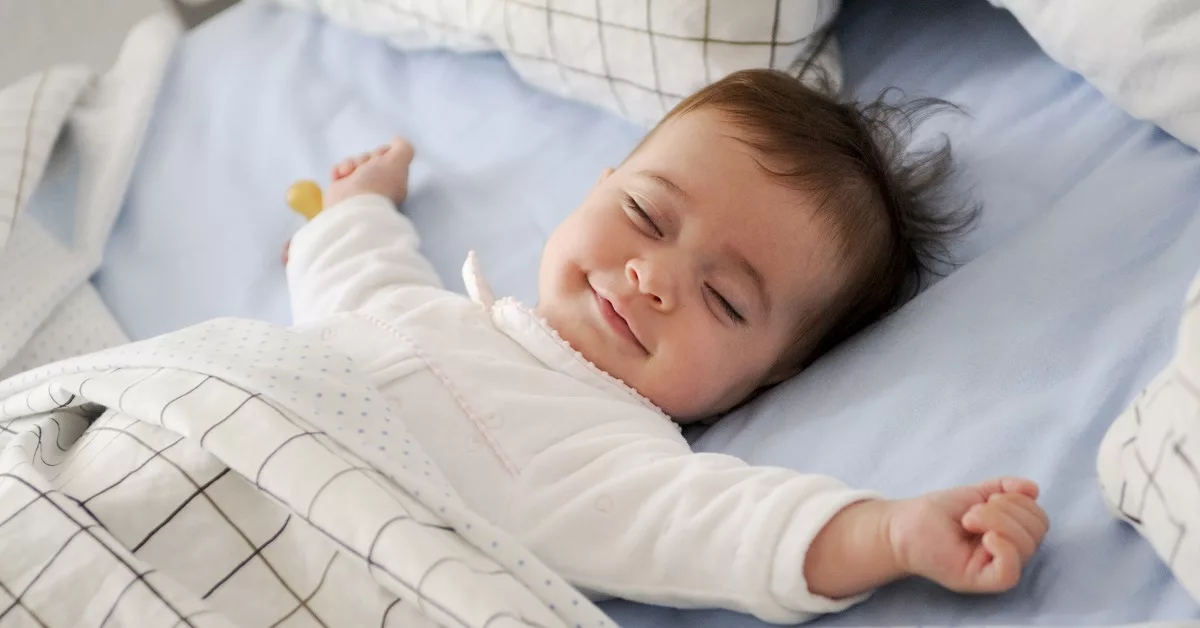 seorang bayi sedang tidur dengan sleep training bayi
