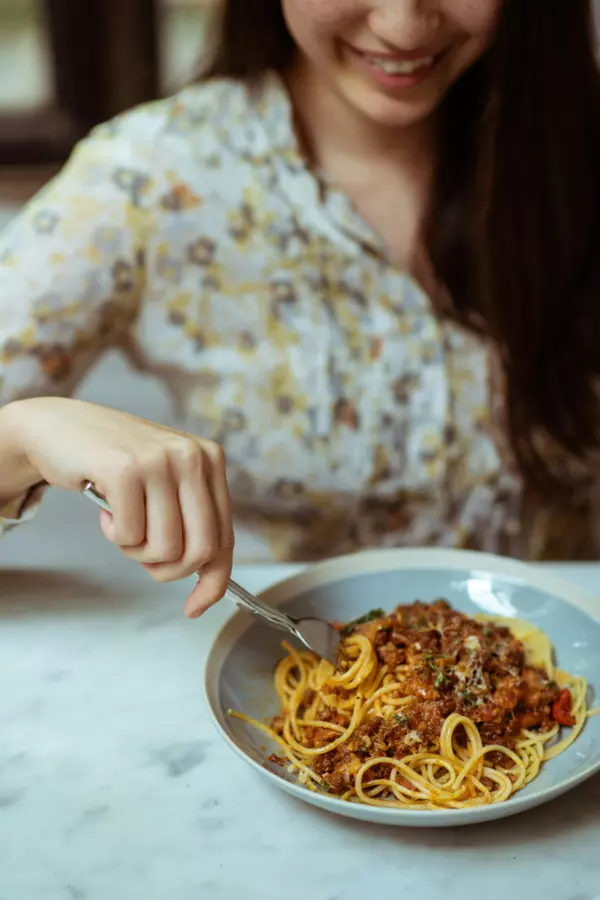 Seorang ibu menyusui yang sedang mengkonsumsi pasta sebagai karbohidrat komplex