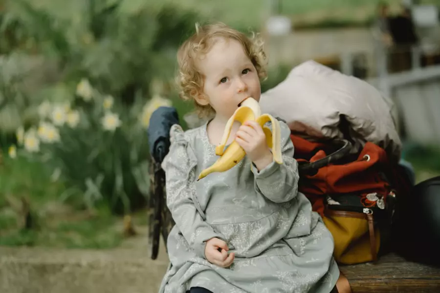 Anak yang sedang memakan pisang sebelum mencoba resep biskuit pisang lezat dan sehat