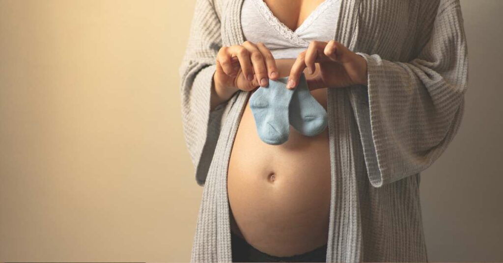 second trimester mother preparing baby socks, week by week pregnancy checklist